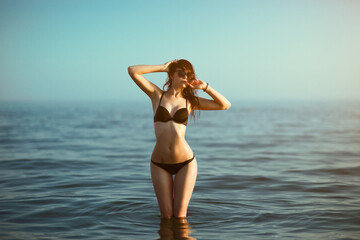 Beautiful girl in a bikini on the sea beach.