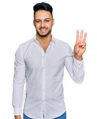 Young arab man wearing casual clothes showing and pointing up with fingers number three while smiling confident and happy.