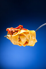 Tagliatelle with clams on a red background