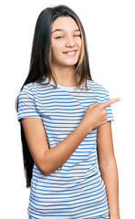 Young brunette girl with long hair pointing with fingers to the side winking looking at the camera...