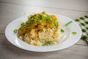 cooked bulgur with meat sauce and vegetables in a plate
