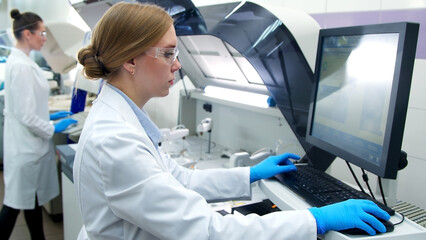 Naklejka premium A medical research laboratory with a diverse team of biochemical scientists working with computers and modern medical technologies. Development of high-tech equipment for medicines.