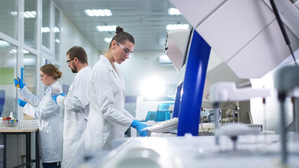 A medical research laboratory with a diverse team of biochemical scientists working with computers and modern medical technologies. Development of high-tech equipment for medicines. - obrazy, fototapety, plakaty