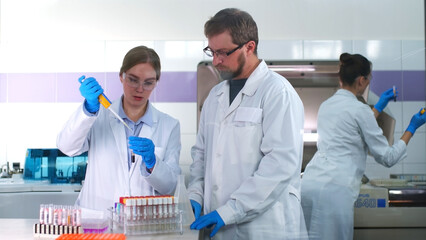 A medical research laboratory with a diverse team of biochemical scientists working with computers and modern medical technologies. Development of high-tech equipment for medicines.