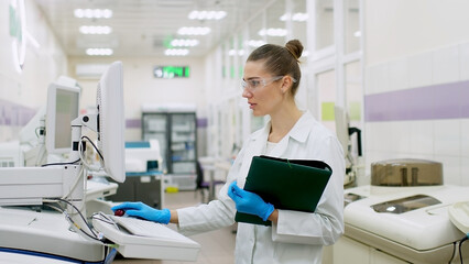 A female scientist controls the operation of devices for laboratory research. Modern laboratory...