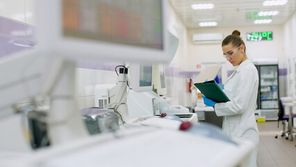 A female scientist controls the operation of devices for laboratory research. Modern laboratory technologies. Medical research centrifuge.