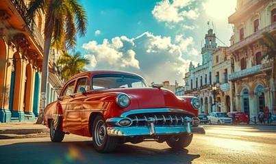 Fototapeten Vintage red classic car cruising on a sunny street in Havana with historical architecture and tropical vibes, capturing the essence of old Cuba © Bartek