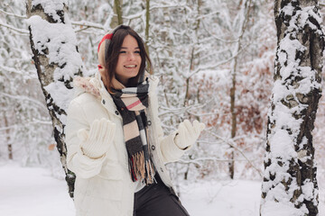 Portrait of a young pretty girl in a winter snowy forest. Happy girl in winter scenery. Portret młodej, ładnej, uśmiechniętej  dziewczyny w zimowym,śnieżnym lesie.  - obrazy, fototapety, plakaty