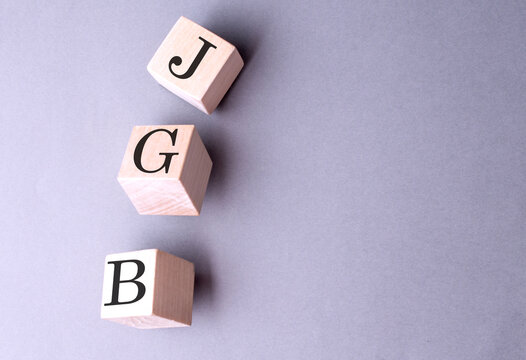Word JGB on wooden block on the grey background