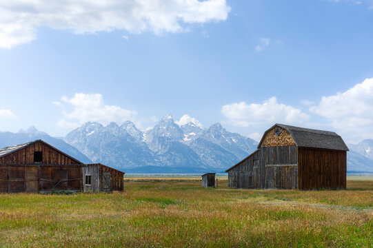 Old, abandoned timber barns and Grand Tetons mountains. Wyoming, USA.