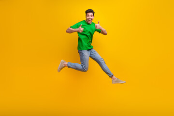 Fototapeta na wymiar Full size photo of satisfied nice guy wear stylish t-shirt run to empty space showing thumbs up isolated on yellow color background