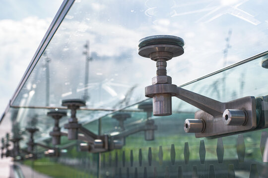 glass roof with steel mounts bolted fixed to transparent wall, architecture of transparent gazebo, on background sky, nobody.