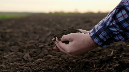 Agricultural industry. Farmer hands hold fertile soil, natural fertilizer, compost. Farmer checks composition of soil before sowing. Man, woman holding land in hands in close-up. Concept agriculture - obrazy, fototapety, plakaty