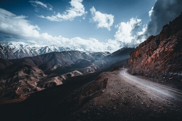 Canyon Curve - A winding dirt road cuts through the rugged terrain of the Atlas Mountains, edged...