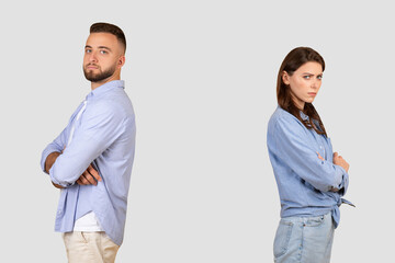 Upset couple standing back-to-back with crossed arms, disagreement concept