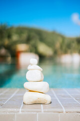pyramid of stones by pool, balanced zen stones, spa and relax concept