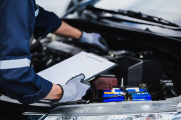 Professional mechanic working on the engine of the car in the garage. Car repair service.
