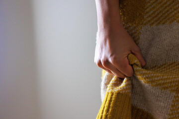 服を握った女性の手元、ダークなイメージ