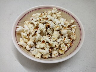 Popcorn in a bowl on a white background, top view.