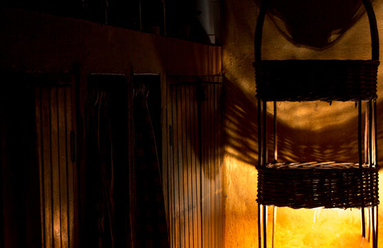 Fruteira feita de vime iluminada no canto da pia da cozinha. 