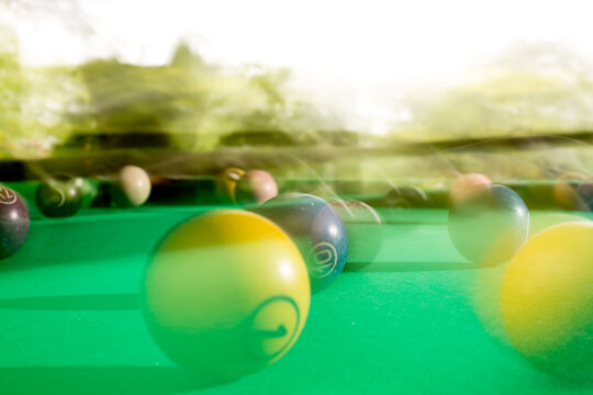 Bolas de bilhar coloridas sobre mesa de sinuca de tecido de cor verde.