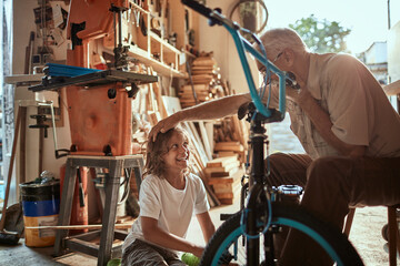 Grandfather and grandson fixing a bike in the garage
