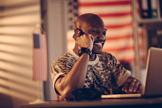 Young American soldier working on laptop at army base