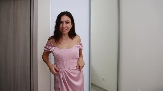 millennial woman in pink evening party dress and other white with features and sequin.girl is choosing, dancing,looking in mirror.female with extra fat can't zip up his dress.natural make up