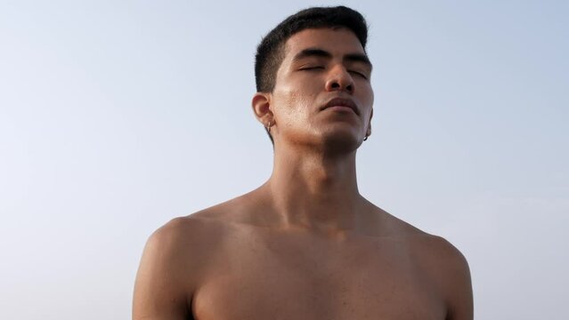Young latino man takes deep beaths with his eyes closed