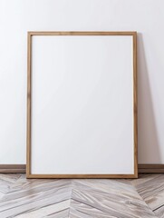 photo of a large blank frame leaning against a white wall.  Large framed art poster mockup on white wall.