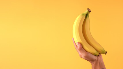 Hand holding banana fruit isolated on pastel background