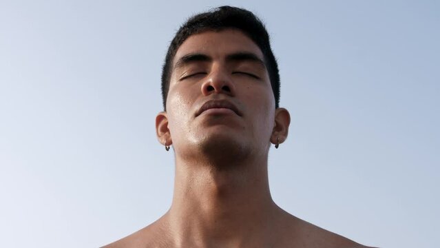 Young latino man takes deep beaths with his eyes closed