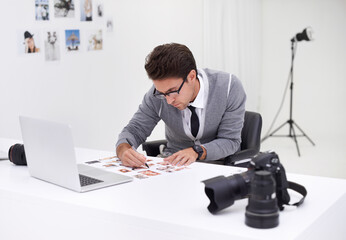 Writing, photography and man in office editing with production, process and technology. Professional, editor and creative person working on desk with photoshoot results, review or notes for magazine