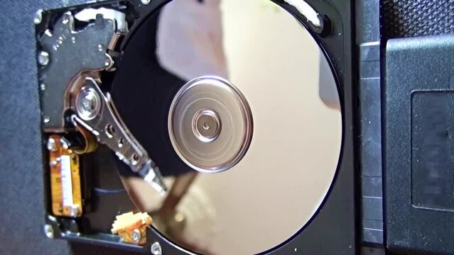 Hard disk drive with removed cover but with the platter spinning and the heads reading. 