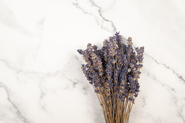 Top view of lavender flowers on white marble background. Lavender bouquet flat lay. Copy space.
