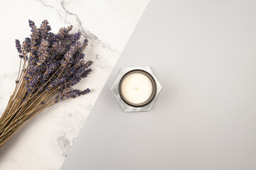 Obraz premium Top view of lavender flowers on grey and white marble background. Lavender bouquet, marble tray and candle flat lay. Copy space. 