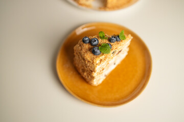 Homemade baked cake Napoleon, Millefeuille. Delicate custard cake garnished with berries and mint. On a gray concrete stone background. High quality photo