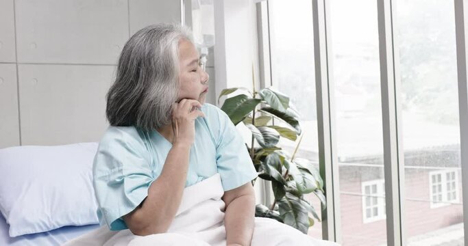 Sick Asian elderly woman lying in hospital suffering from stress and depression caused by anxiety due to diabetes, blood pressure, cholesterol and heart disease. Health care in retirement