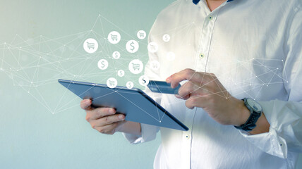 Close up hand holding tablet and use credit for online shopping payment, banking and financial technology or fintech on bright background.Business and financial concept.