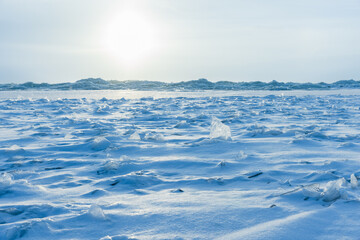 Empty winter landscape with frozen Baltic sea under blue sky