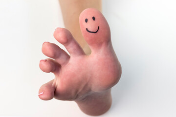 Closeup of a female toes with a smile drawn on them.