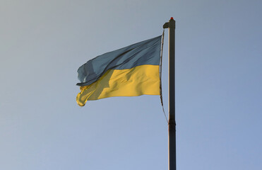 Ukraine flag large national symbol fluttering in blue sky. Large yellow blue Ukrainian state flag,...