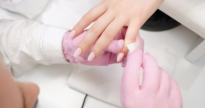 Finalization of nails for gel nail polish cover in the salon, master.