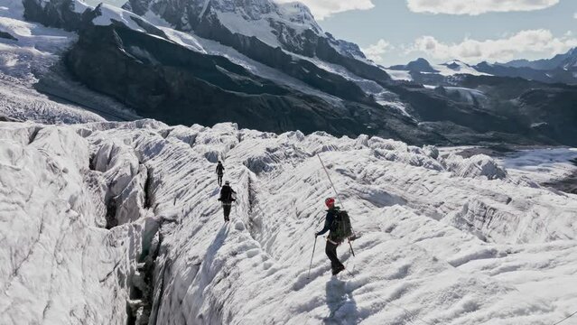 People climb the Monte Rosa glacier in Switzerland. Their bodies cast shadows on the ice