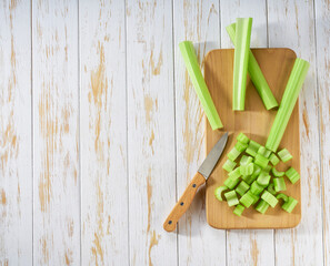fresh celery sticks on a wooden table, top view.