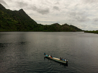 Fototapeta na wymiar a boat is on the water near a beach in maluku