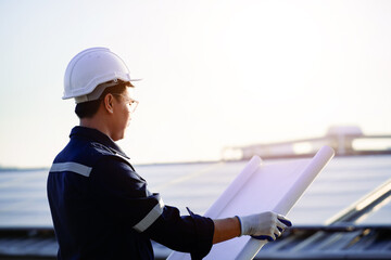 Engineer standing at power station looking at production planning work Inspect and repair solar...