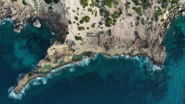 Aerial view of a rocky coastline with cliffs facing the Mediterranean Sea on Ibiza island, Balearic Islands, Spain.