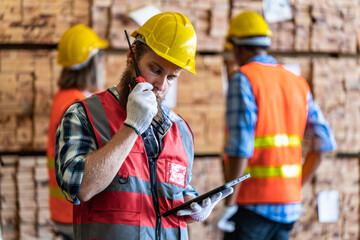 workers man and woman engineering walking and inspecting with working suite dress and hand glove in the front machine. Concept of smart industry worker operating. Wood factories produce wood timber.