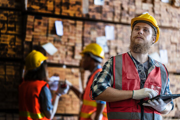 workers man and woman engineering walking and inspecting with working suite dress and hand glove in the front machine. Concept of smart industry worker operating. Wood factories produce wood timber.